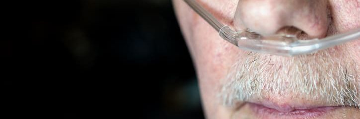 Older man's face with oxygen cannula being used