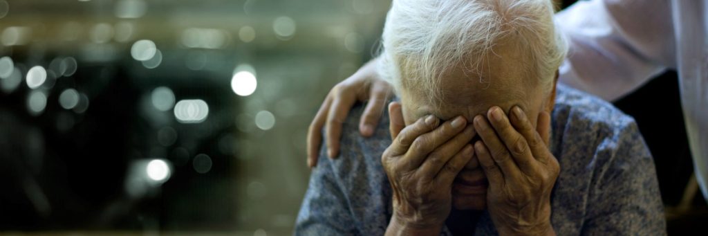 Caregiver comforting sad elderly woman, Alzheimer's disease, dementia, loss, depression