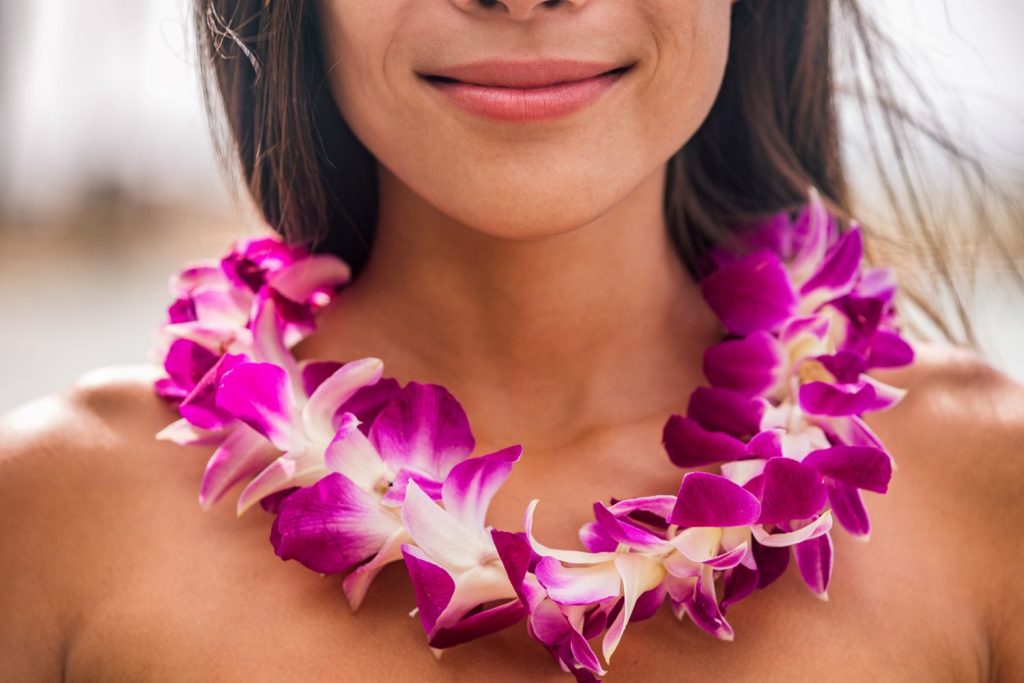Lei hawaii welcome necklace of fresh orchids flowers garland on woman's neck. Aloha spirit. Hula dancer, luau, photo