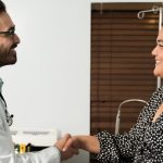 Happy doctor shaking hand of obese woman female patient in office, obesity, photo