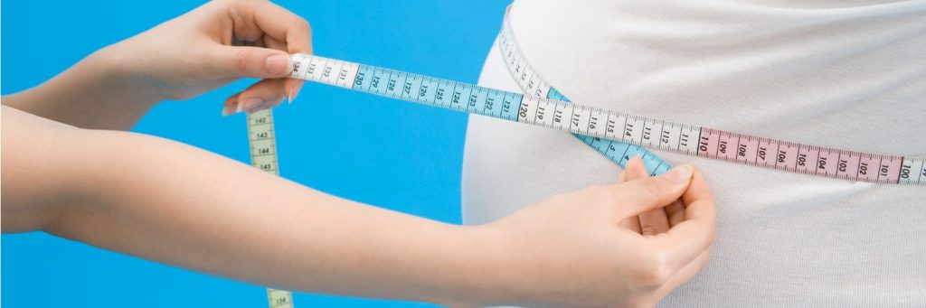 Woman using measuring tape to measure obese man waist, obesity, metabolic syndrome
