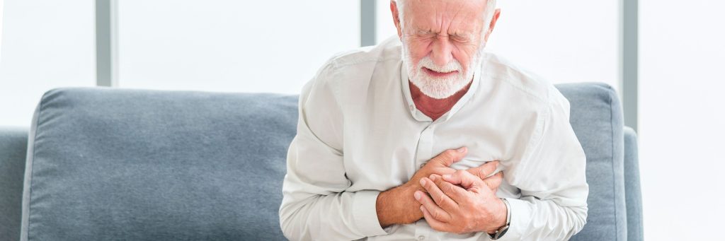 cardiac events in patients with RSV, Senior male asian suffering from bad pain in his chest heart attack at home. Senior heart disease. Man with chest pain suffering from heart attack at home