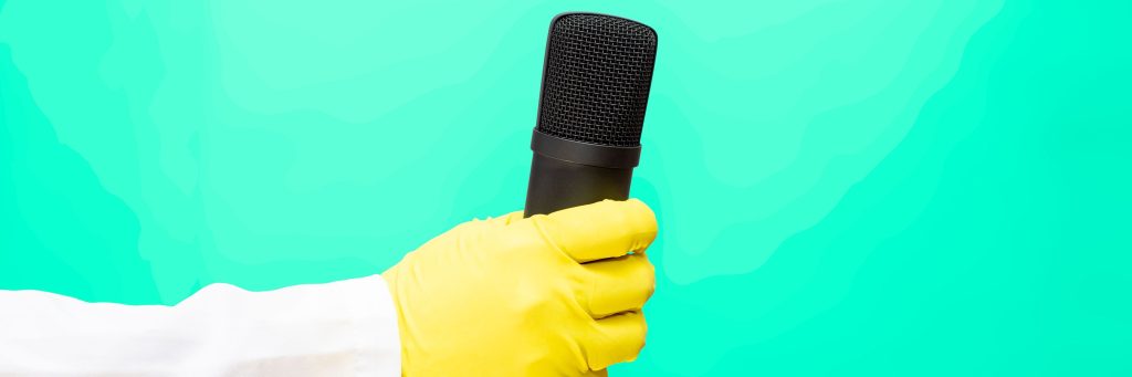 A doctor in a medical gown and protective gloves holds a microphone. interview, share experiences